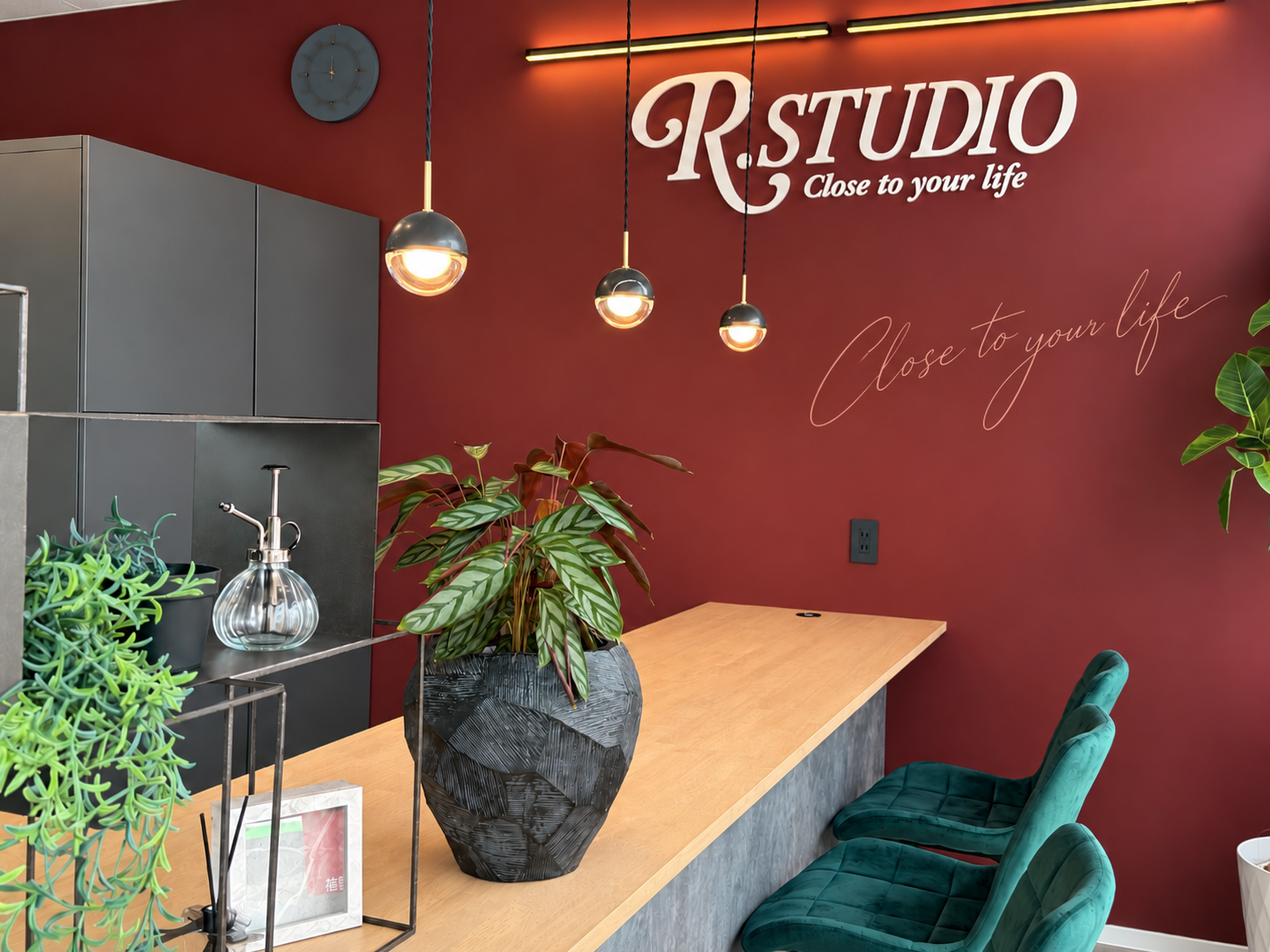 R.STUDIO 店内。えんじ色の壁に掲げられたR.STUDIOのロゴサイン