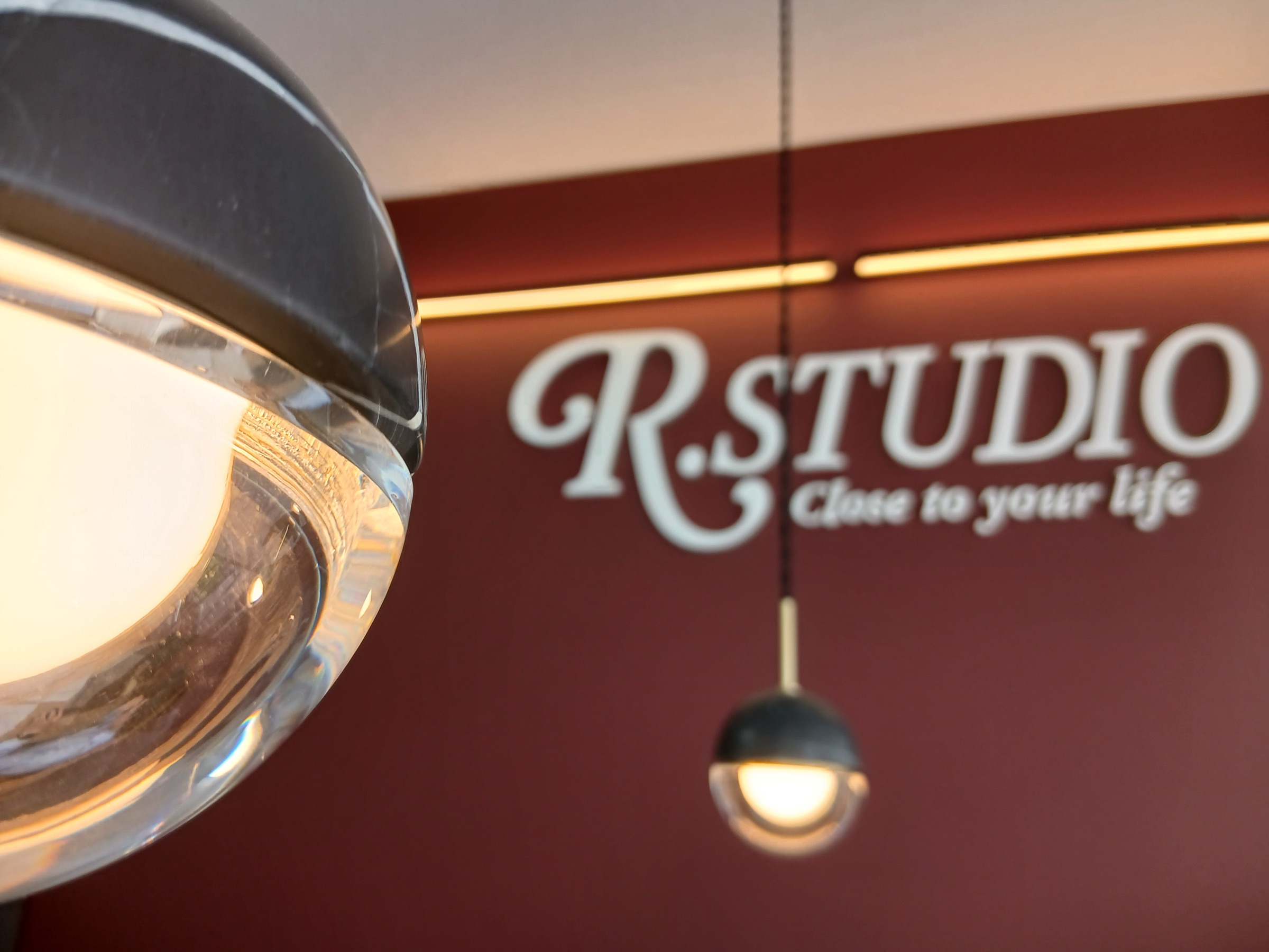 R.STUDIO 店内のペンダントライトとえんじ色の壁